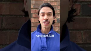 JohnRoss in a blue shirt discussing soulful interior design, standing against a brick wall with the word 'seduction' overlaid on screen.