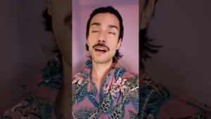 JohnRoss expressing emotion while discussing the tragedy of soulless interior design, wearing a bold floral shirt against a mauve background.