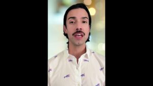 JohnRoss in a white shirt with playful pink and blue animal prints, speaking on how interior design choices influence the nervous system and emotional well-being.