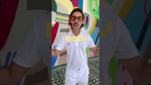 JohnRoss wearing a white polo in front of a colorful mural, teaching about calming paint colors and interior design tips for nervous system support.