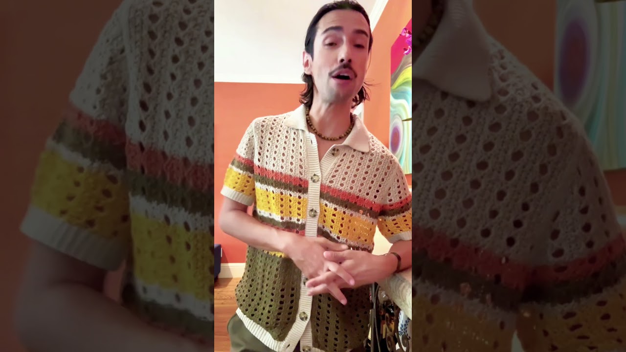 JohnRoss wearing a vintage crochet shirt in a warm-toned room, explaining story-driven interior design tips for creating timeless and meaningful homes.