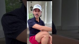 Interior designer John Ross sitting on porch steps in a Kentucky Derby hat, sharing 4th of July hosting tips focused on emotional design and guest experience.