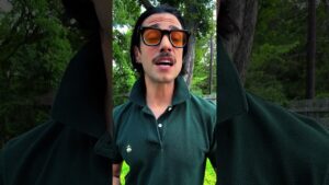 JohnRoss outdoors in a dark green polo and amber sunglasses, highlighting the need for stillness and natural light in interior design to escape trend fatigue.