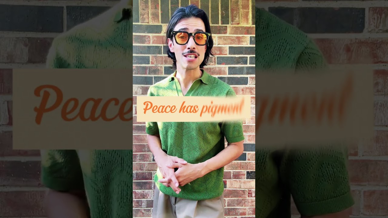 JohnRoss wearing a green knit polo against a brick wall, sharing soulful interior design tips on moving beyond neutral tones to create authentic, lively homes.